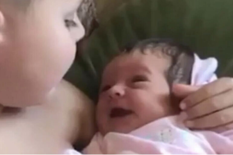 Boy holds his baby sister for the first time and her serenades her with “What a Wonderful World”