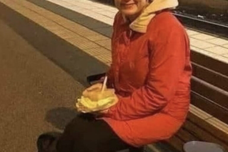 A woman is waiting for a train to return home